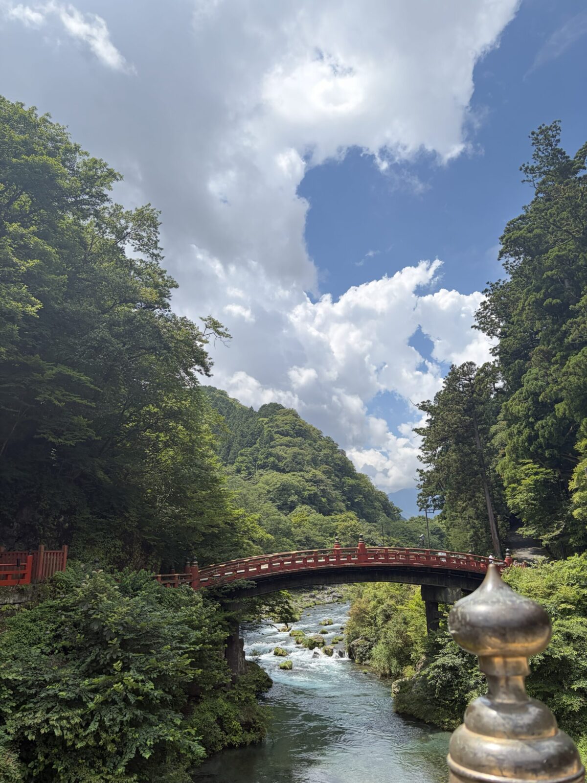 日光駅方面へ下る途中にある朱色の神橋と大谷川の透明度の高い水面